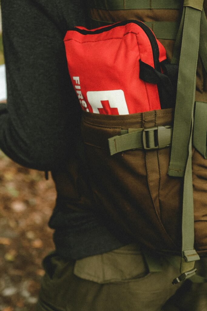 A Person with Red First Aid Kit in Backpack Pocket